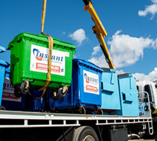 Numerous large recycling bins on the back of a truck in different colours